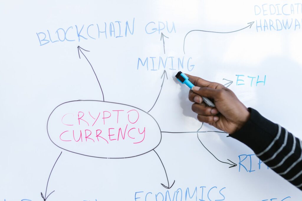 Person studying cryptocurrency with laptop and educational materials.